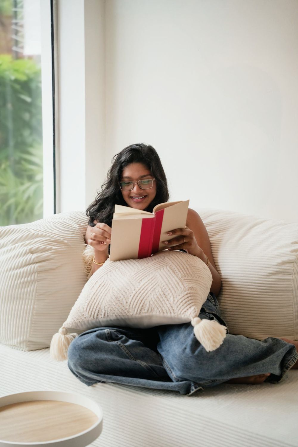 Someone curled into the corner of the Cloud Sofa with a book, afternoon light across the cushions.